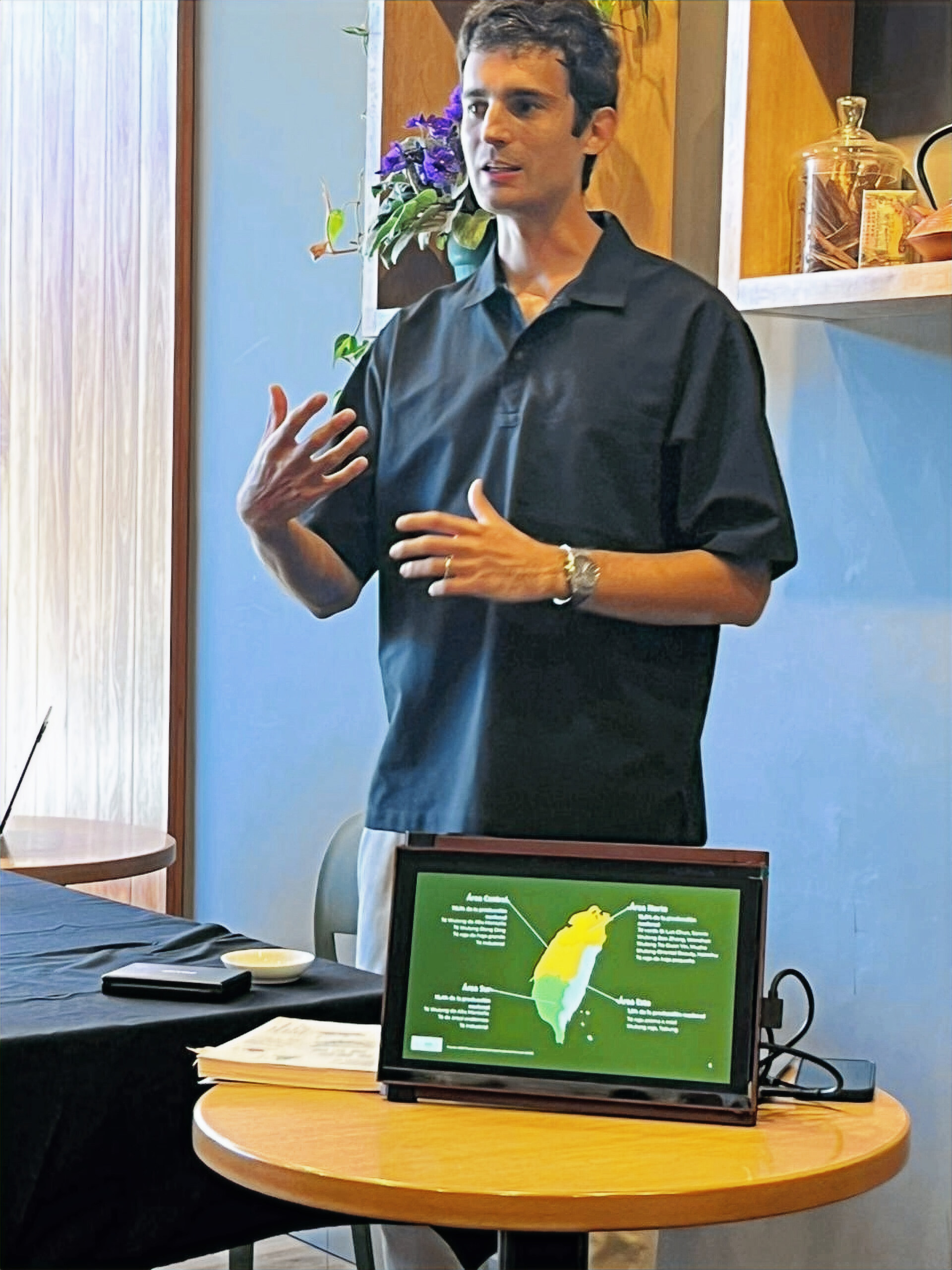 José Ellena giving a tea presentation with a map of Taiwan on screen